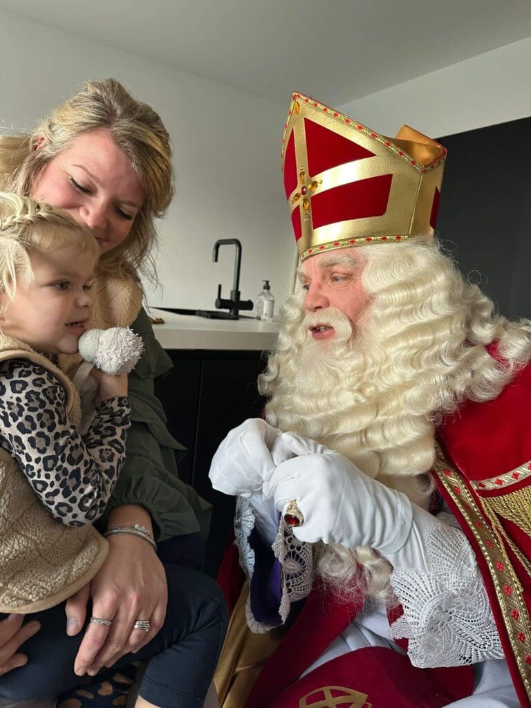 Sinterklaas tijdens persoonlijk huisbezoek met ouder en kind