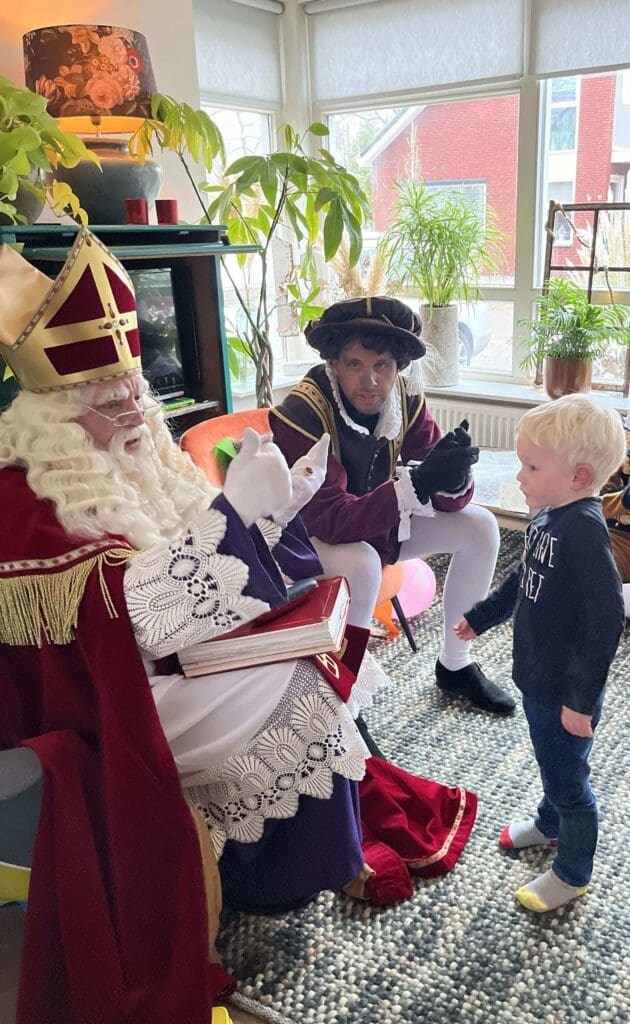 Kind in gesprek met Sinterklaas en Piet tijdens huisbezoek